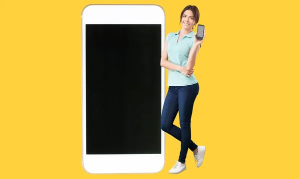 Wanita Bahagia Bersandar Pada Smartphone Besar Dengan Layar Kosong — Stok Foto