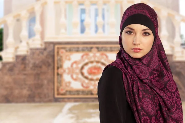イスラム教徒の女の子置くAスカーフ上の彼女の頭の上に屋外の背景 — ストック写真