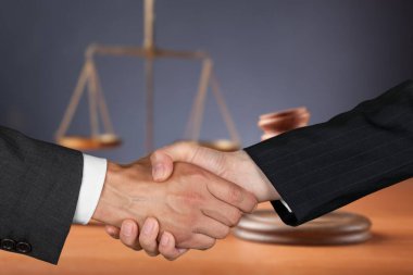 Avukat ve müvekkil, davayı kazandıktan sonra, dolandırıcılık davaları kavramı ile el sıkışıyor..