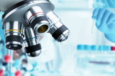 Laboratuvarda mikroskopla çalışan bir bilim adamının yakın çekimi.