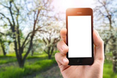 Çiftçi bir akıllı telefon tutuyor ve manzaraya dokunuyor.