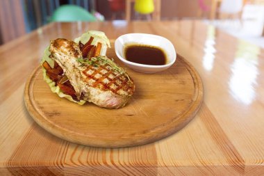 Lezzetli ızgara biftek, sebze ve ahşap tahtada sos.