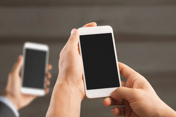 Två Moderna Smartphones Med Tomma Skärmar Människohänder — Stockfoto