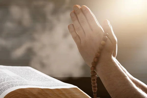 用神圣的圣经在木制桌子上祈祷的手 — 图库照片