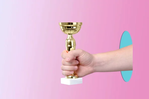 Mão Segurando Copo Troféu Ouro Fundo Rosa — Fotografia de Stock