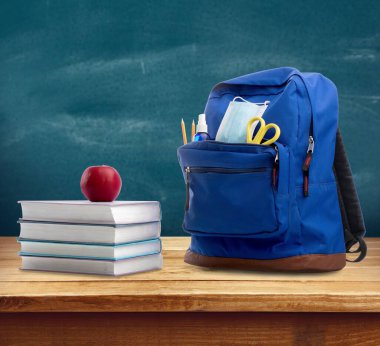 Sırt çantasında kitap ve elma var.