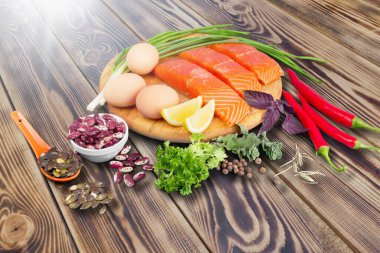 Tahta arka planda taze somon ve sebzeler