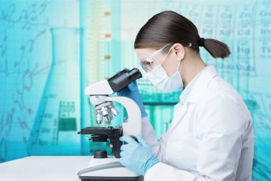 Tıbbi mikroskop kullanarak test sonuçlarını analiz eden bilim kadını.