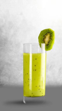 Beyaz arka planda bir bardak taze kivi püresi.