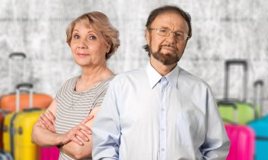 Stüdyo portresi. Mutlu, evli, seyahat bavullu bir çift..