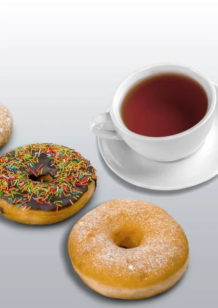 Arka planda çörekler olan bir fincan çay, yakın plan.