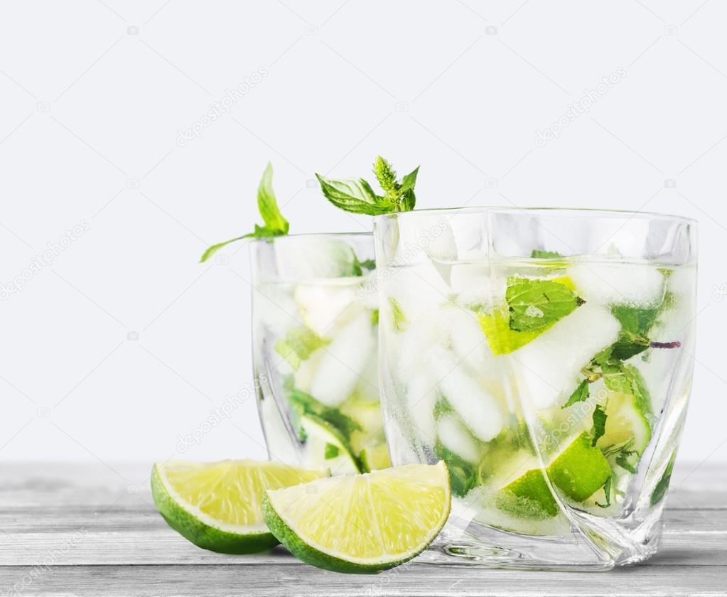 Mojito. Cold mojito drink, glass of alcohol isolated over white background, fresh mint and lime fruit slice, food still life, party and holidays celebration