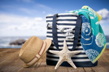 Yaz. Yaz plaj çantası ve saman şapka kum plajındaki closeup.