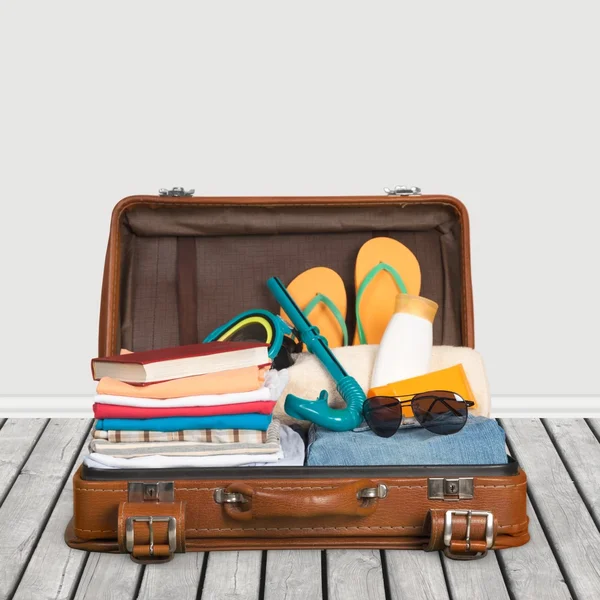 Utazás. Csomagolt vintage bőrönd, tele nyaralás elemek — Stock Fotó