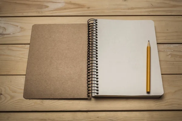 Arriba. Un cuaderno de bocetos vintage abierto o un cuaderno con lápiz en una mesa de madera vieja . —  Fotos de Stock