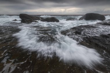 Su kıyıdaki kayalara akıyor.
