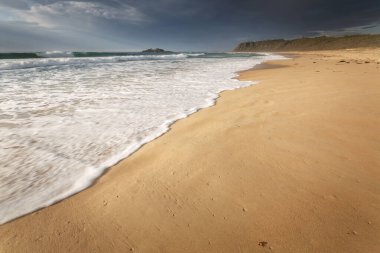 Okyanusun yanında kumlu bir sahil.