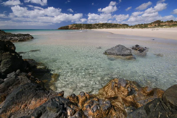 Een Rotsachtig Strand Naast Een Plas Water — Stockfoto