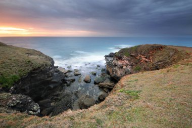 Bir su kütlesinin yanında kayalık bir yamaç.