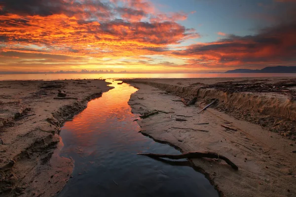 a sunset over a body of water in port douglas