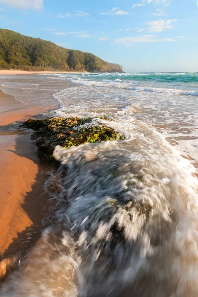 해변의 바위에 쏟아지는 — 스톡 사진