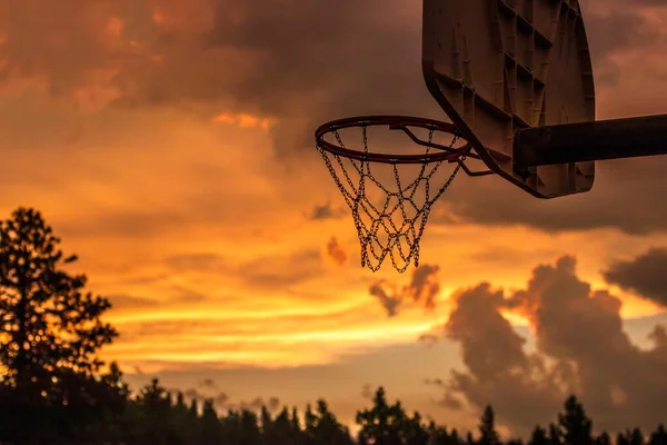 Backlit steel chain net basketball net at sunset