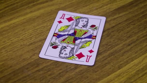 La carte à jouer tourne sur une table en bois — Video