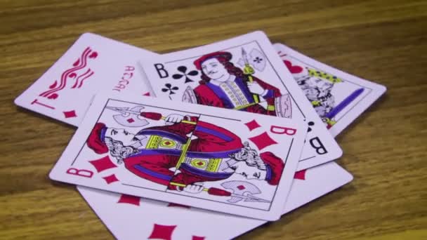 Spielkarten rotieren auf einem Holztisch — Stockvideo