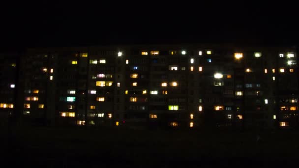 Edificio de varios pisos con iluminación cambiante de ventanas por la noche. Tiempo de caducidad — Vídeo de stock