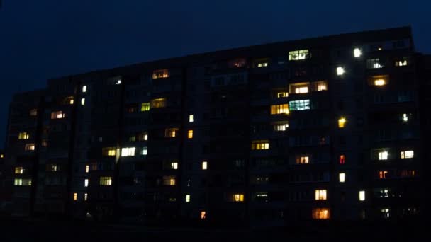 Edificio de varios pisos con iluminación cambiante de ventanas por la noche. Tiempo de caducidad — Vídeo de stock