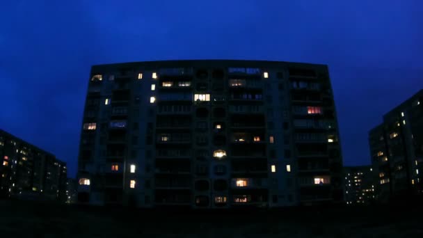 Edificio de varios pisos con iluminación cambiante de ventanas por la noche. Tiempo de caducidad — Vídeo de stock