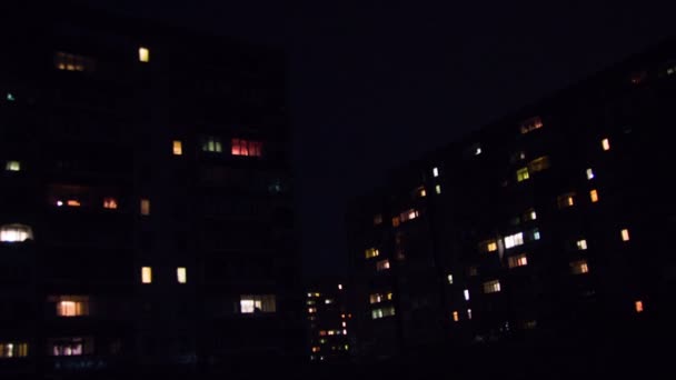 Edificio de varios pisos con iluminación cambiante de ventanas por la noche. Tiempo de caducidad — Vídeos de Stock