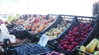 Semt pazarı vitrinde meyve seçme kadın