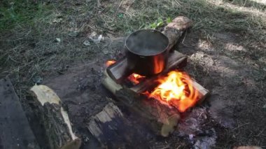 Bir kamp ateşi turizm Pot, üzerinde yemek yemek