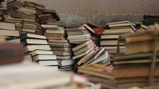 Une pile de livres éparpillés sur le sol dans la bibliothèque — Video