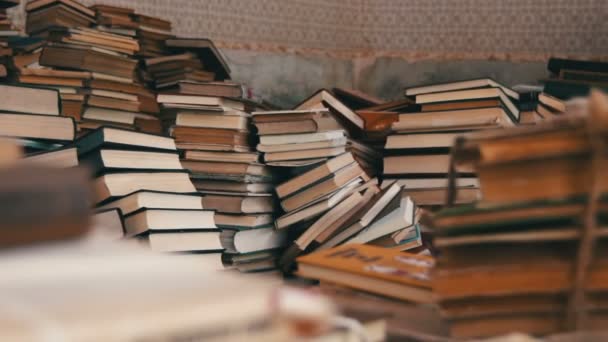 Стопка книг на полу в библиотеке — стоковое видео