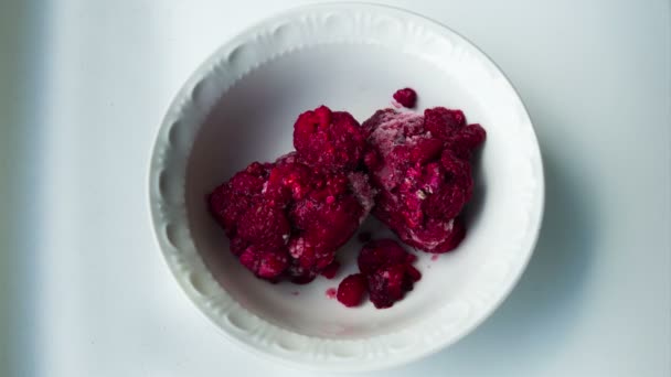 Frozen Raspberries Melting in a Plate on a White Background. Time Lapse — Stock Video