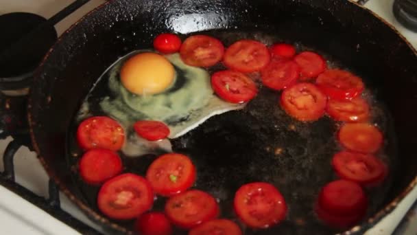 Gebakken eieren met tomaten bereid op een koekenpan — Stockvideo