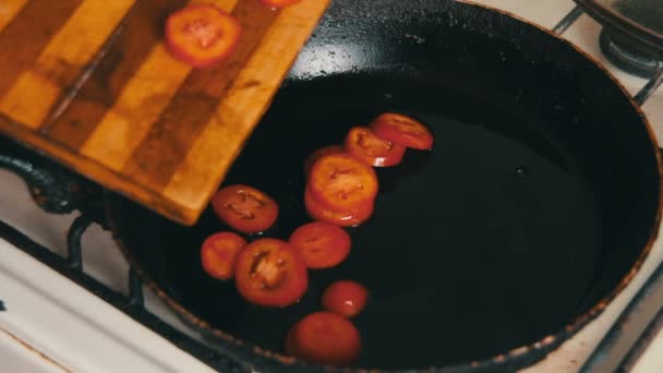 Os tomates de redução fritam-se no óleo de azeitona — Vídeo de Stock