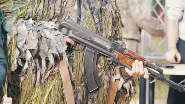 Militaire in Camouflage met een machinegeweer in de hand is de moeite waard op straat — Stockvideo