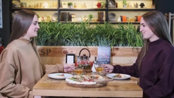 Restoranda Genç Kadın İkizler Yemeği. İkiz kızlar pizza yer. Yavaş Hareket — Stok video