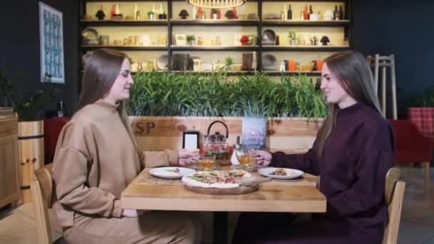 Restoranda Genç Kadın İkizler Yemeği. İkiz kızlar pizza yer. Yavaş Hareket — Stok video