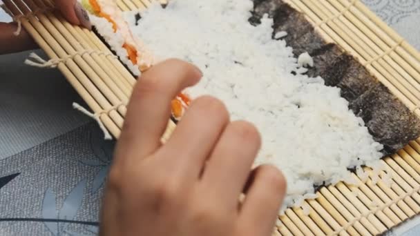 Sushi Rolls maken bij Home Kitchen. De handen van de vrouw wikkelen het Nori blad in. — Stockvideo