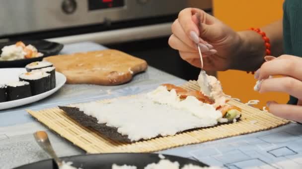 Hacer sushi en la cocina casera. Manos de niña pone ingredientes en la hoja de Nori — Vídeos de Stock