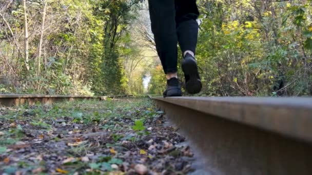 Jonge vrouwen die per spoor lopen op het spoor. Achteraanzicht op Benen. Langzame beweging. — Stockvideo