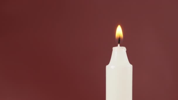 Ένα ενιαίο κερί είναι Lit σε ένα πράσινο φόντο. Φωτισμός. Φλόγα κεριού — Αρχείο Βίντεο