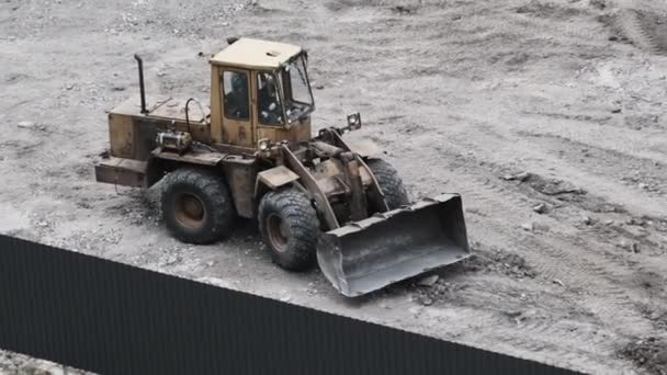 An Old Bulldozer on Rubber Wheels Works on Construction Site. — Stock Video