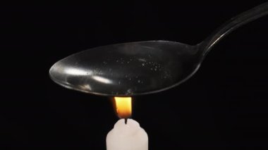 Mum Alevi üzerinde Kaşıkla Eroin pişirmek. Bir Dose hazırlar. Sert Uyuşturucular.
