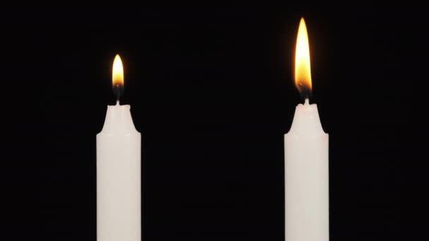 Dos velas están ardiendo en un fondo negro cerca. Iluminación. — Vídeos de Stock