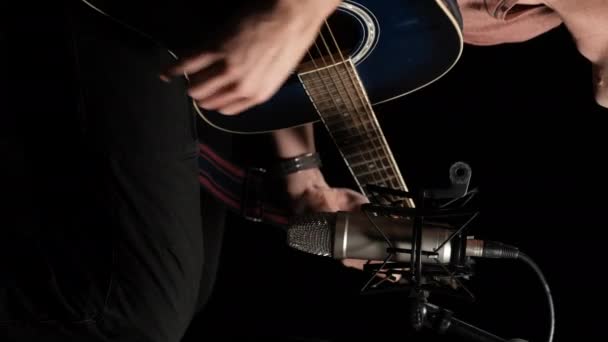 Вертикальное видео. Acoustic Guitar Records on Studio Microphone on Black Backdrop — стоковое видео